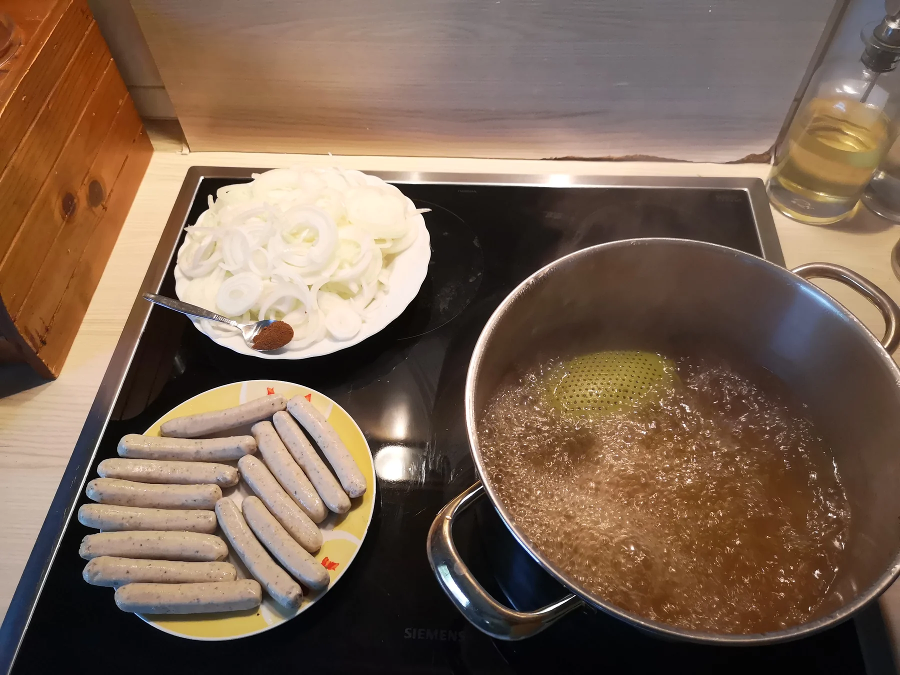 Vorbereitete Zwiebeln, Bratwürste und Gewürzsud